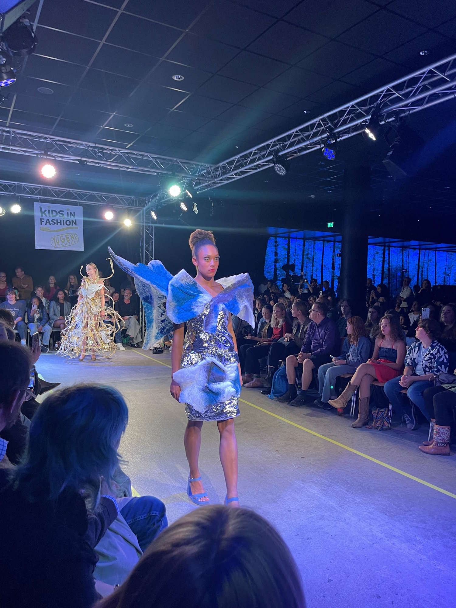 Jugend-Fashion-Show in Wien: Models präsentieren ausgefallene Kreationen auf dem Laufsteg vor Publikum.